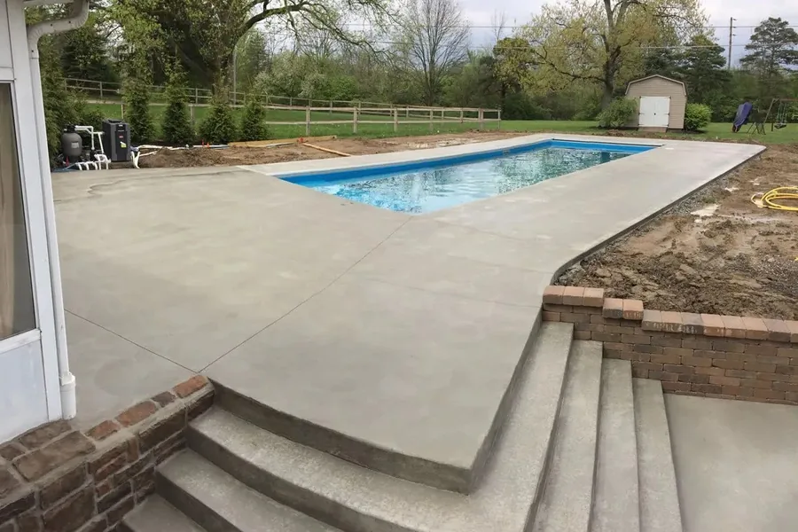 Concrete pool deck and patio with stairs